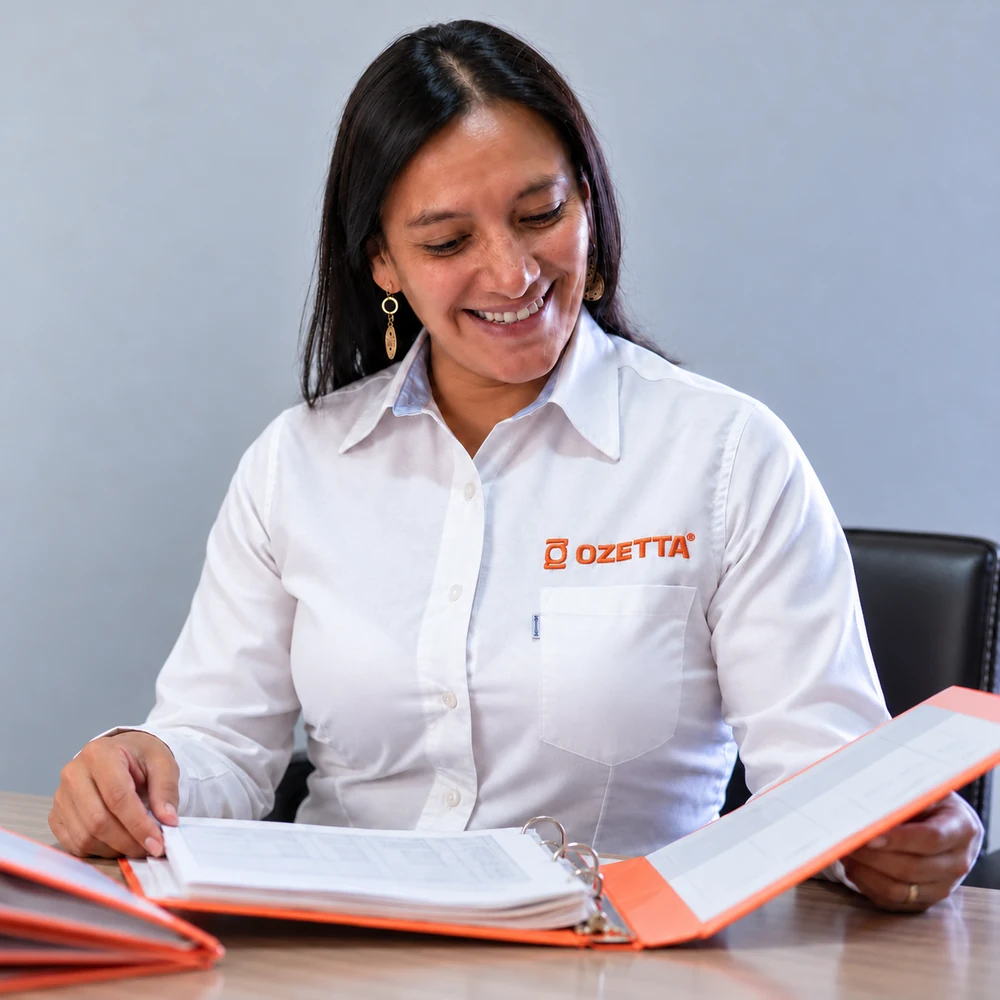 Administrativa de Ozetta revisando una carpeta de documentación de servicio